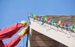 person hanging led lights on house