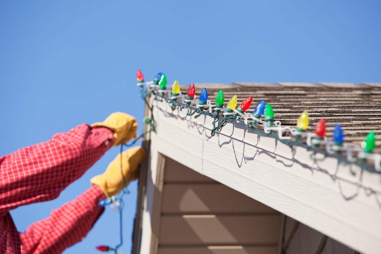 person hanging led lights on house