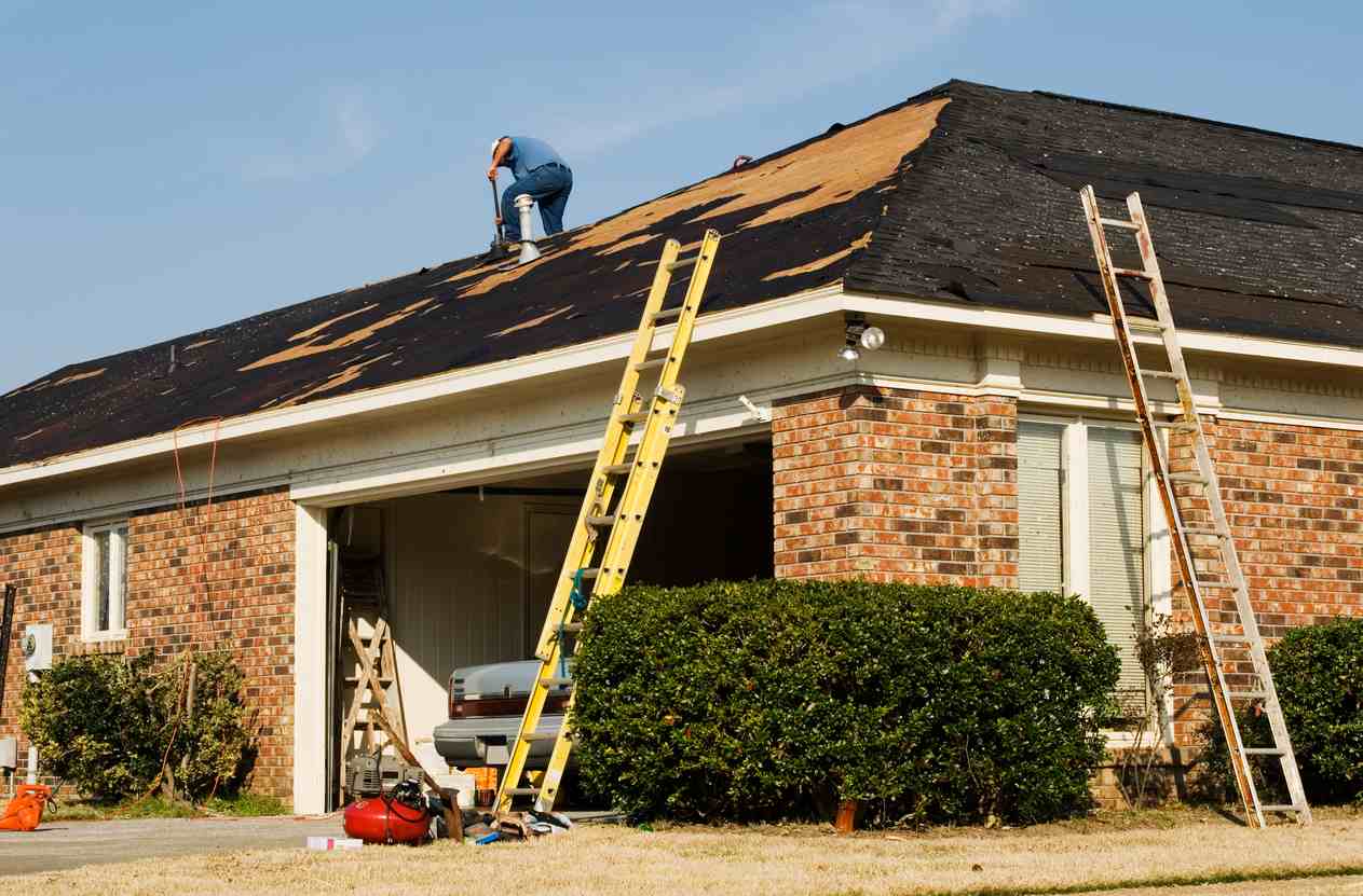 man on roof after storm